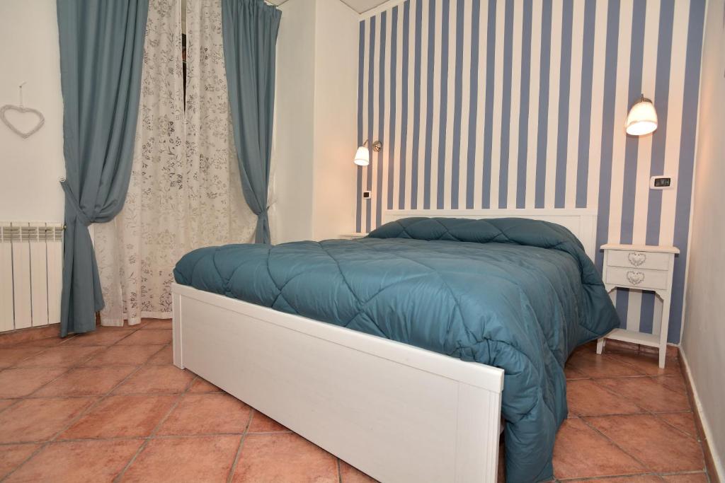 een slaapkamer met een bed met een blauw dekbed bij Residenza Maranto in Napels