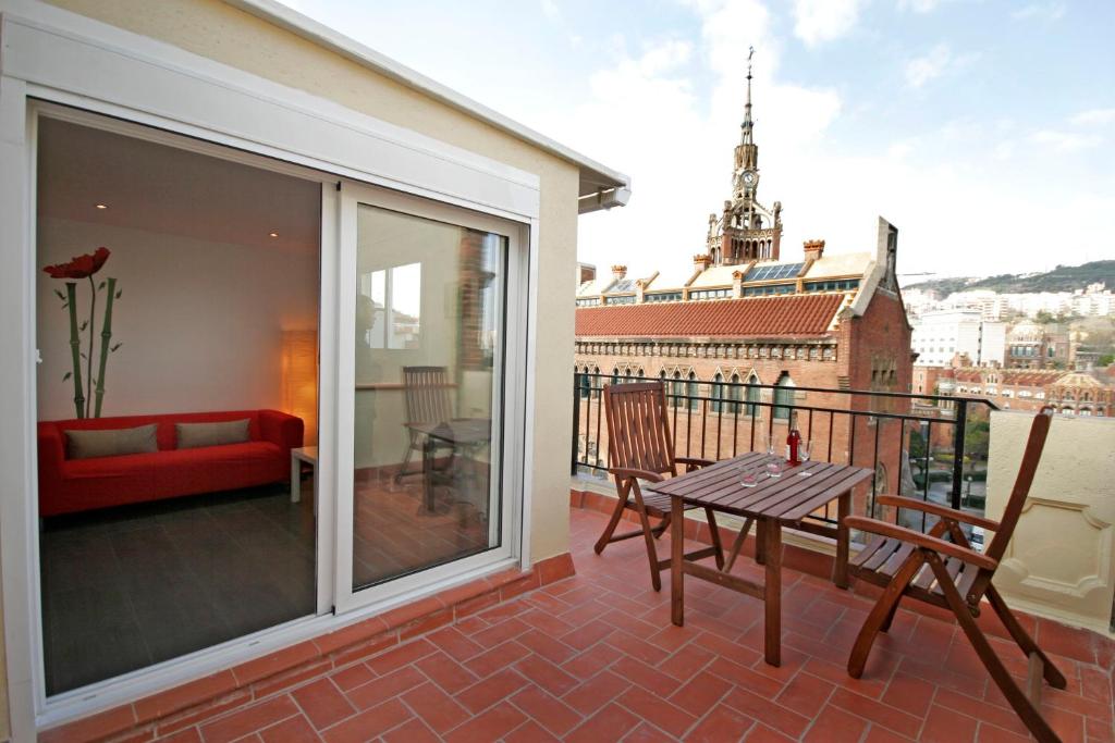 a patio with a table and chairs on a balcony at Sant Pau Terraces Apartments in Barcelona