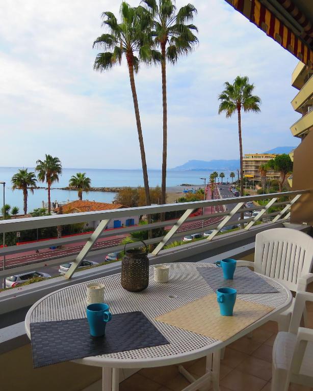 stół na balkonie z palmami i oceanem w obiekcie Casa Lea w mieście Ventimiglia