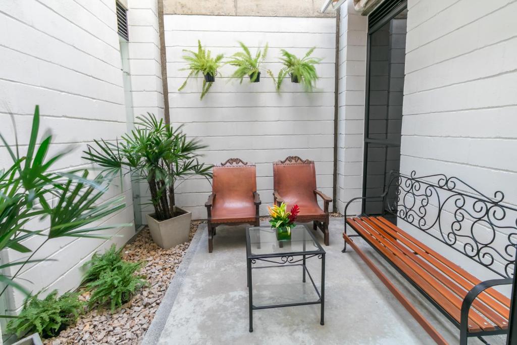 two chairs sitting on a porch with plants at Hotel Casa Vallecaucana in Cali