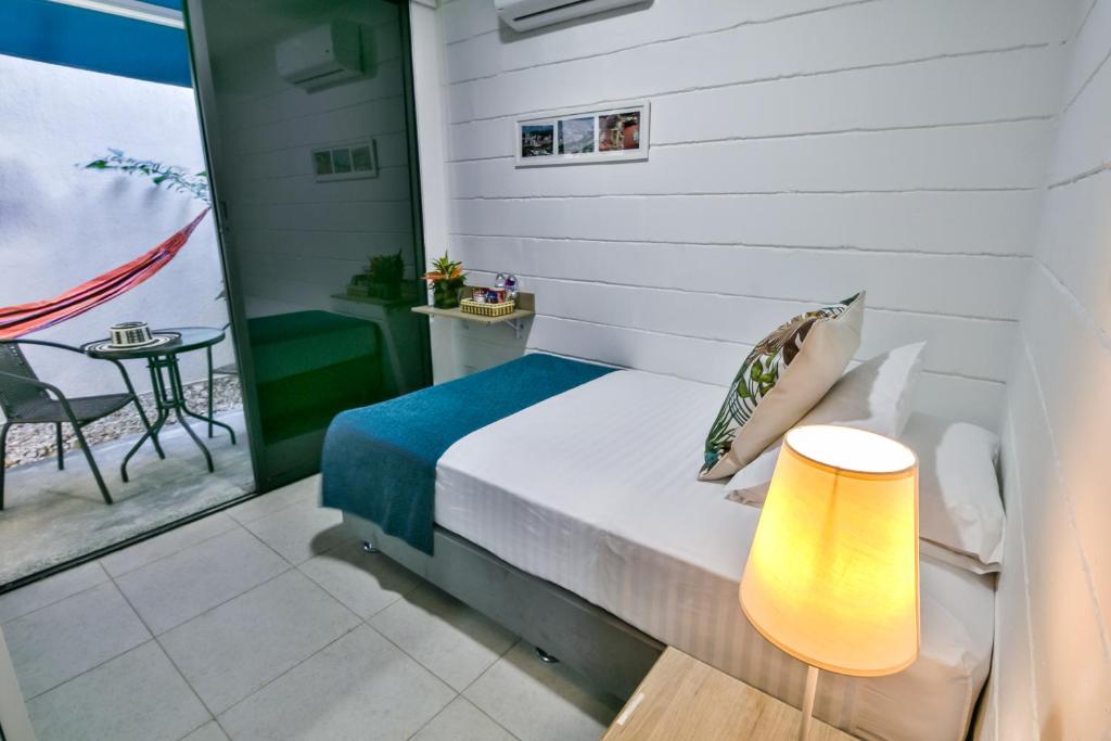 a bedroom with a bed with a lamp and a table at Hotel Casa Vallecaucana in Cali