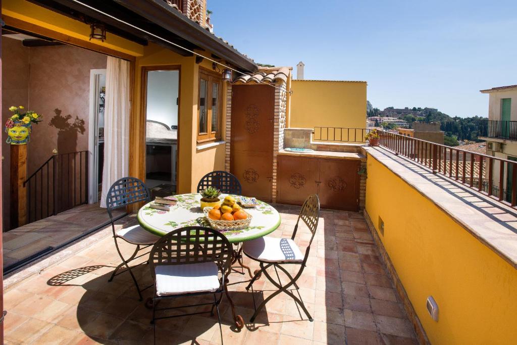 een patio met een tafel en stoelen op een balkon bij Taormina al Bacio apartment in Taormina
