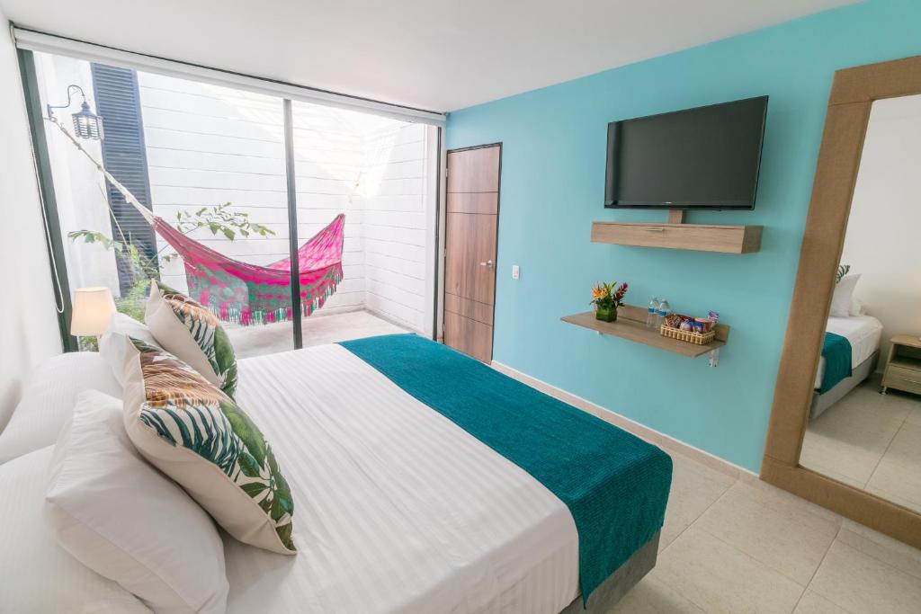 a bedroom with a large bed and a tv at Hotel Casa Vallecaucana in Cali