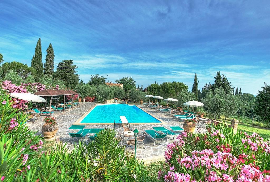 una piscina con sillas, sombrillas y flores en Montelopio by PosarelliVillas en Montelopio