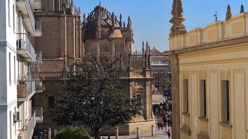 um edifício com uma árvore no meio de uma rua em Preciosas Vistas a Catedral em Sevilha