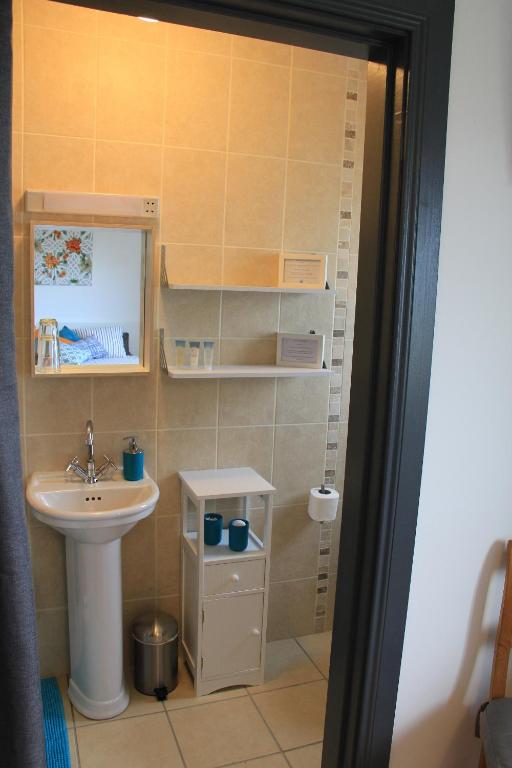 un piccolo bagno con lavandino e specchio di Uisce Beatha House B&B a Portmagee