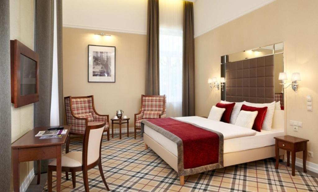 A bed or beds in a room at Mirage Medic Hotel