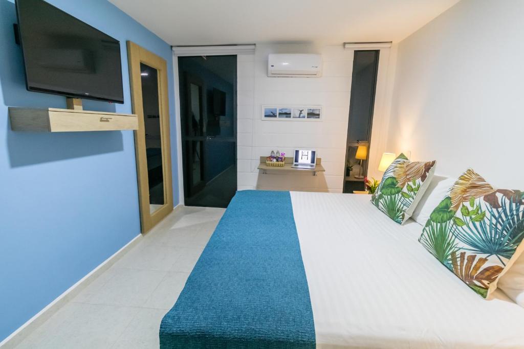 a bedroom with a large bed with a blue carpet at Hotel Casa Vallecaucana in Cali