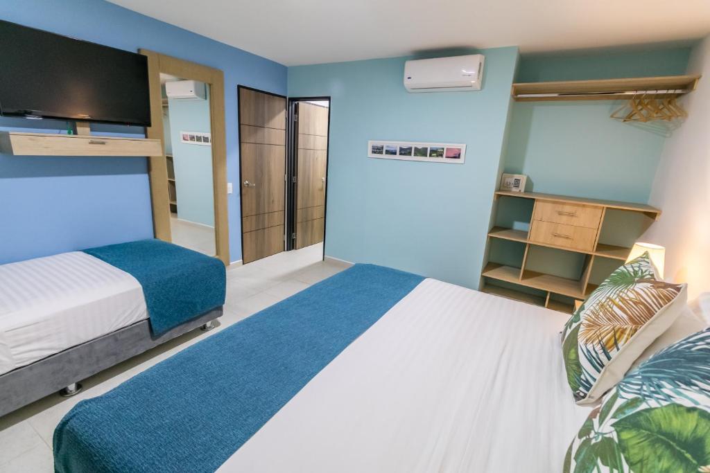 a bedroom with a bed and a blue wall at Hotel Casa Vallecaucana in Cali