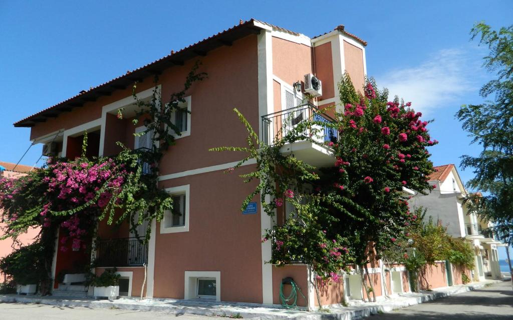un edificio con dei fiori sul lato di Konstantinos Apartments a Ayia Evfimia