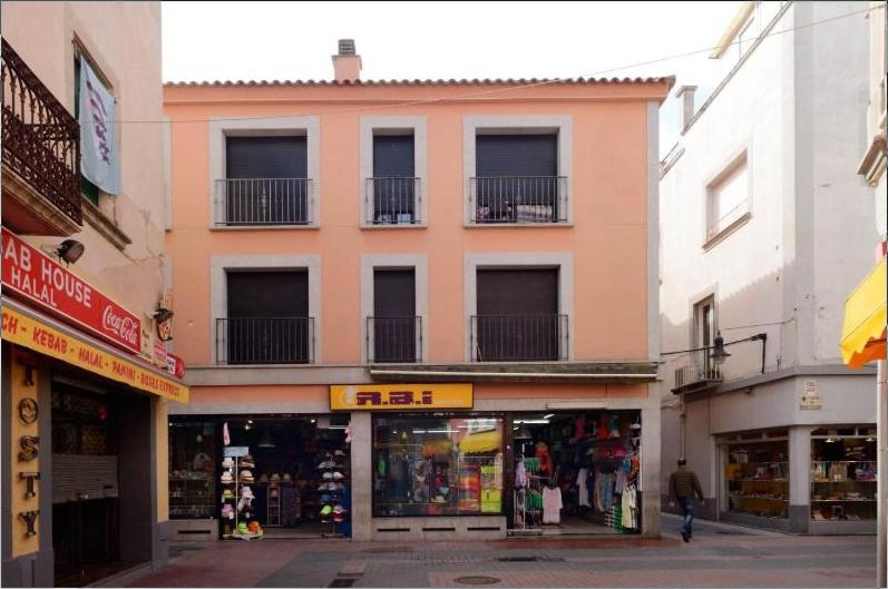 un edificio en una calle de la ciudad con tiendas en Apartaments Yaco en Lloret de Mar