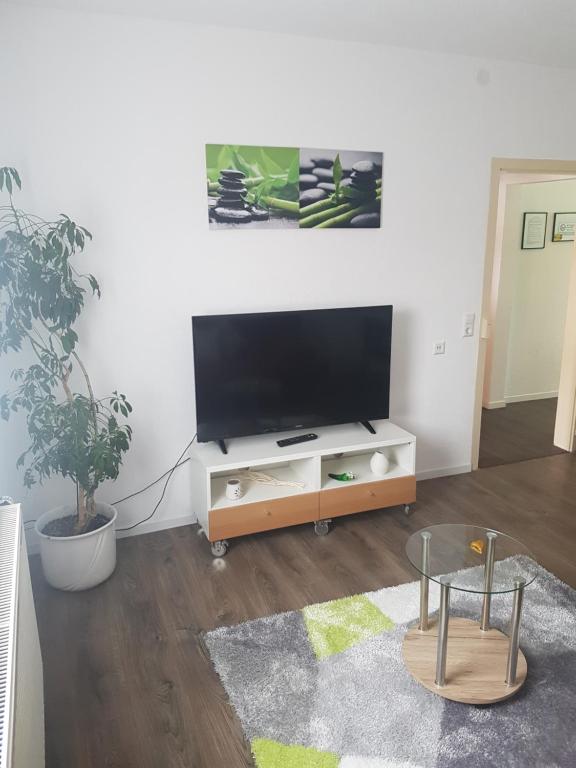 a living room with a flat screen tv on a stand at Schöne, private Wohnungen in Aalen