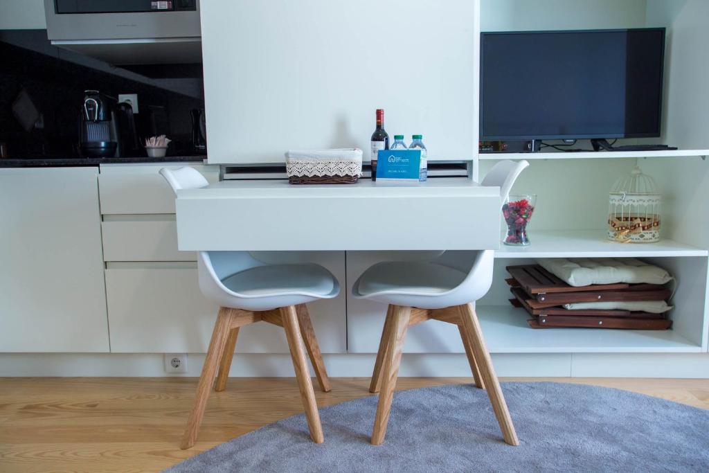 a white desk with two chairs in a kitchen at Almada Story Apartments by Porto City Hosts in Porto