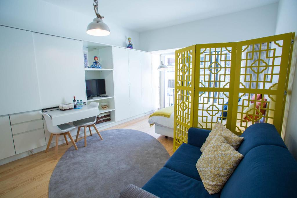 a living room with a blue couch and a table at Almada Story Apartments by Porto City Hosts in Porto