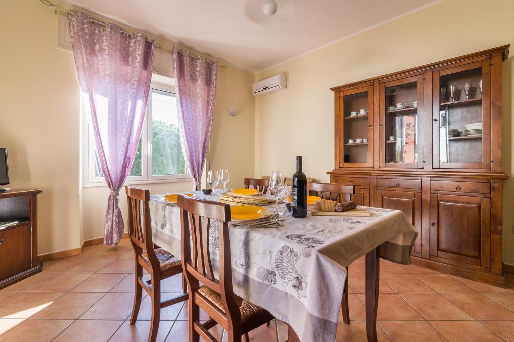 a dining room with a table and chairs and a window at Casa Giovanni in Cala Gonone