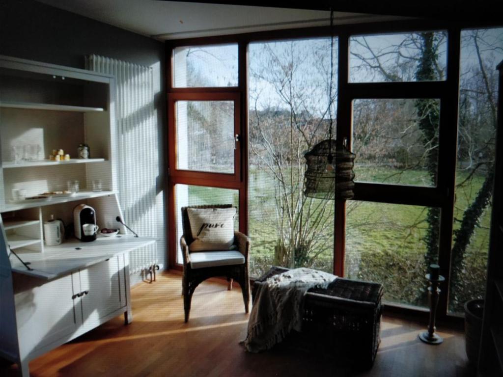ヴンストルフにあるSuite ! Moin Die Rattanbudeの椅子と大きな窓が備わる客室です。