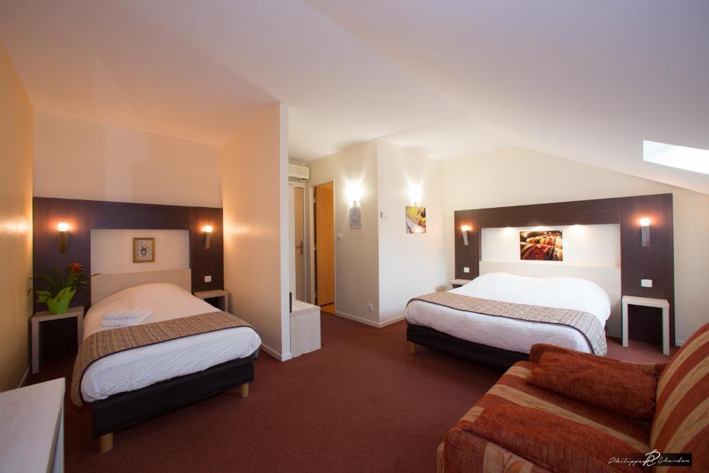 pokój hotelowy z 2 łóżkami i kanapą w obiekcie Logis Jum'Hotel w mieście Saints-Geosmes