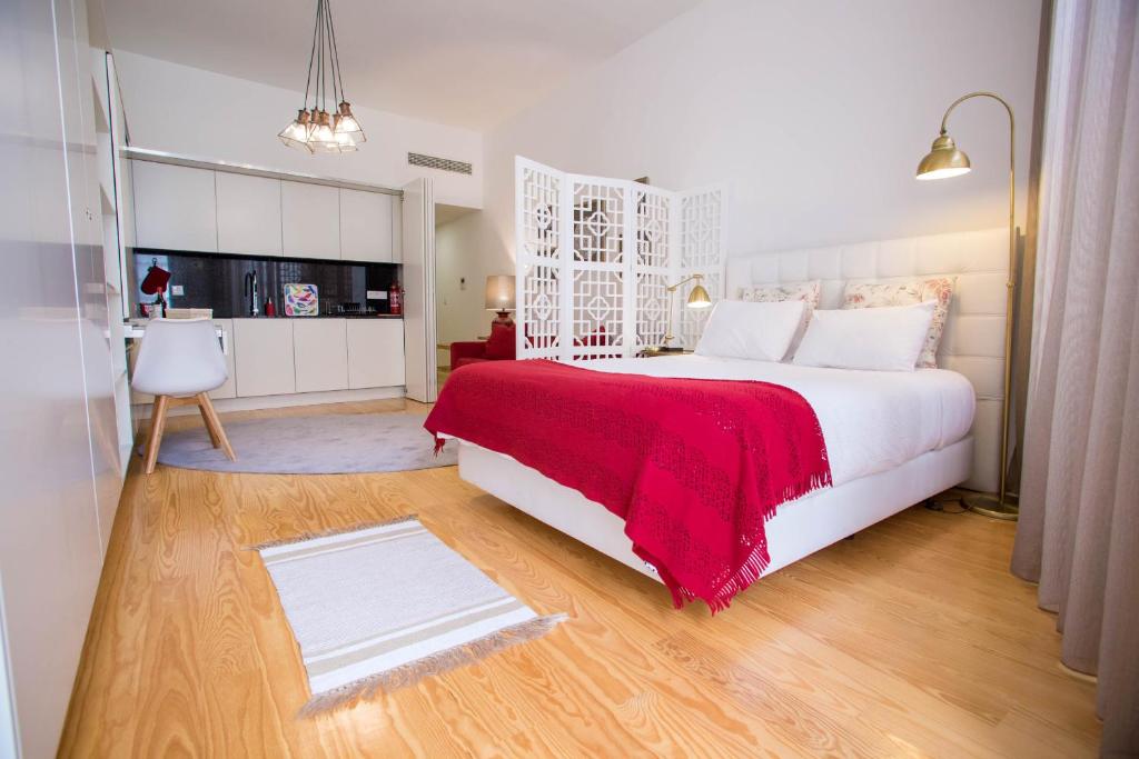a bedroom with a large white bed with a red blanket at Almada Story Apartments by Porto City Hosts in Porto