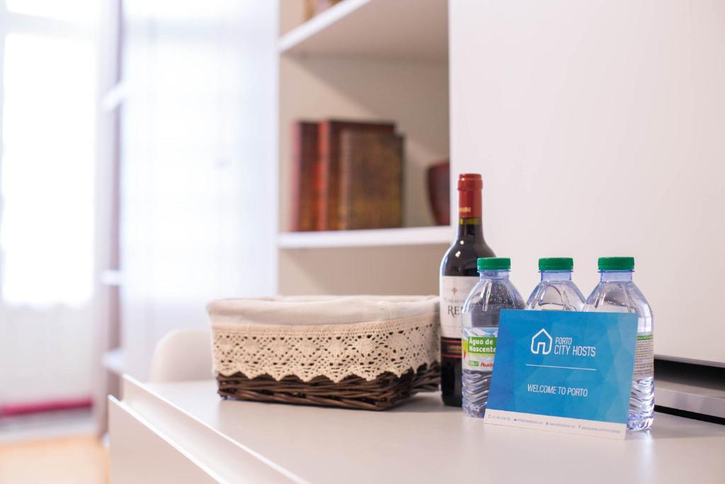 three bottles of water and a basket on a counter at Almada Story Apartments by Porto City Hosts in Porto