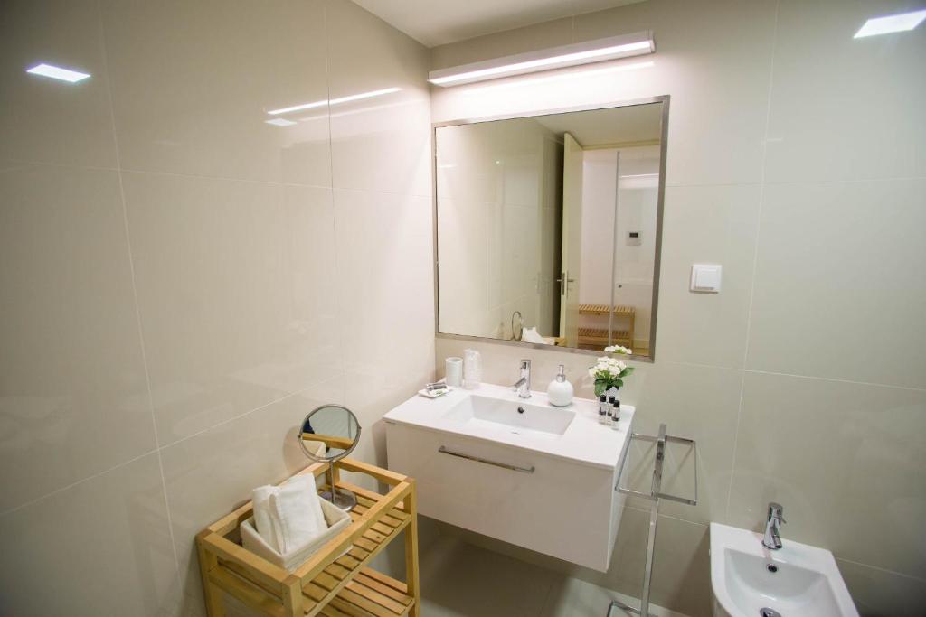 a bathroom with a sink and a mirror at Almada Story Apartments by Porto City Hosts in Porto