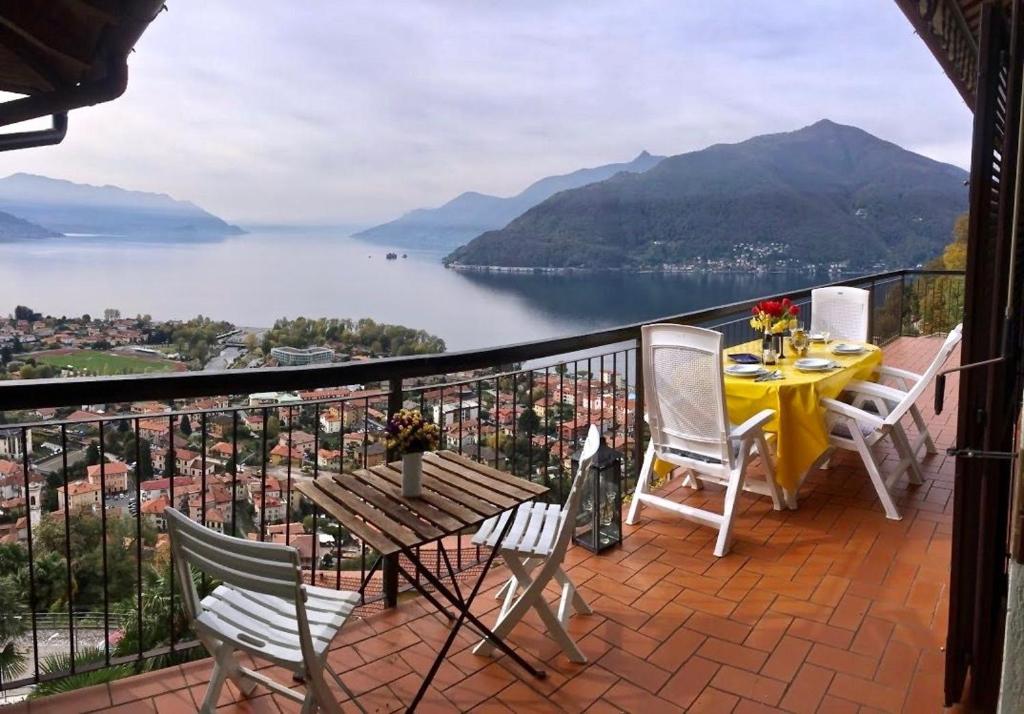 a balcony with a table and chairs and a view of a lake at Pandora 1 in Maccagno Inferiore