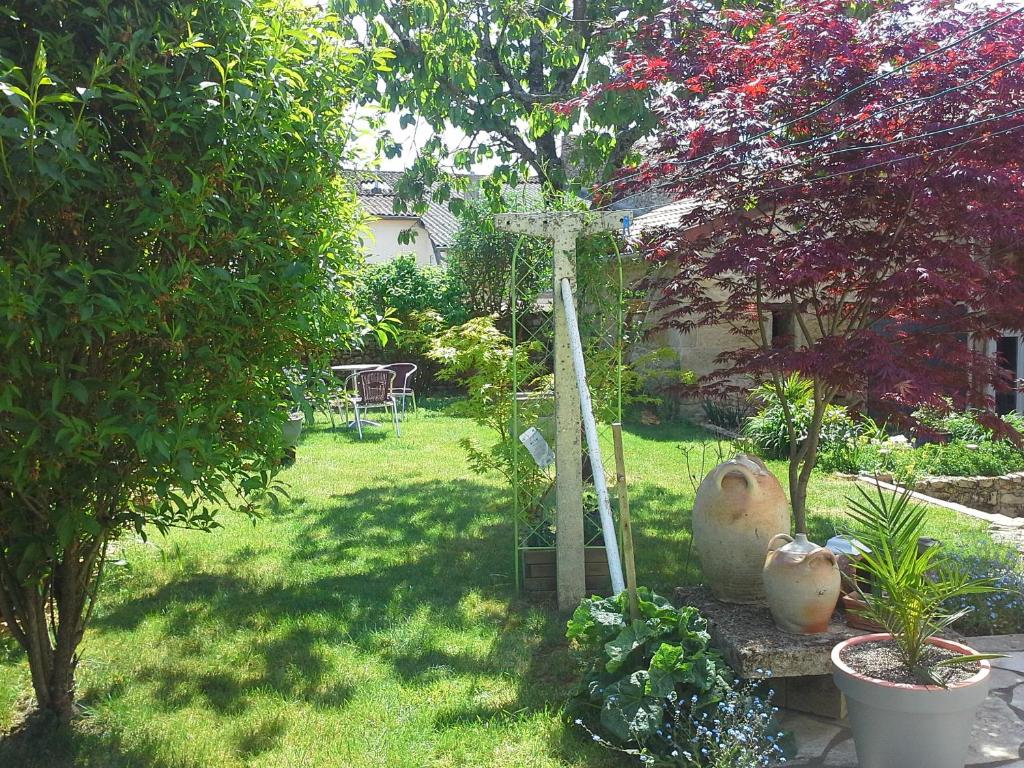 un jardin avec deux vases assis dans l'herbe dans l'établissement Le Logis Du Four, à Soudan