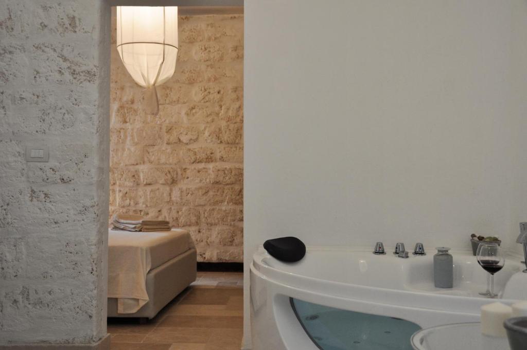 a bathroom with a bath tub and a bed at Donna Piera - Dimore di Charme in Monopoli