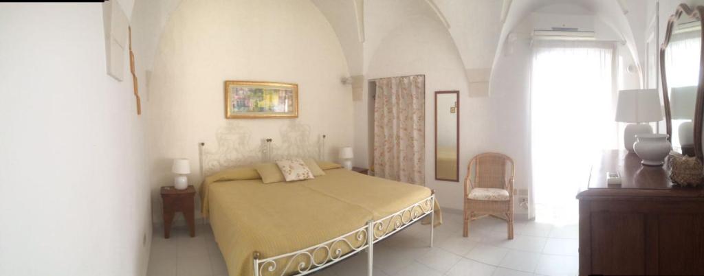 1 dormitorio con 1 cama en una habitación blanca en Villaggio In Case Sparse Nel Centro Storico, en Martina Franca