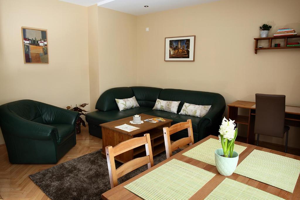 a living room with a green couch and a table at ECOmfort Apartment in Kecskemét