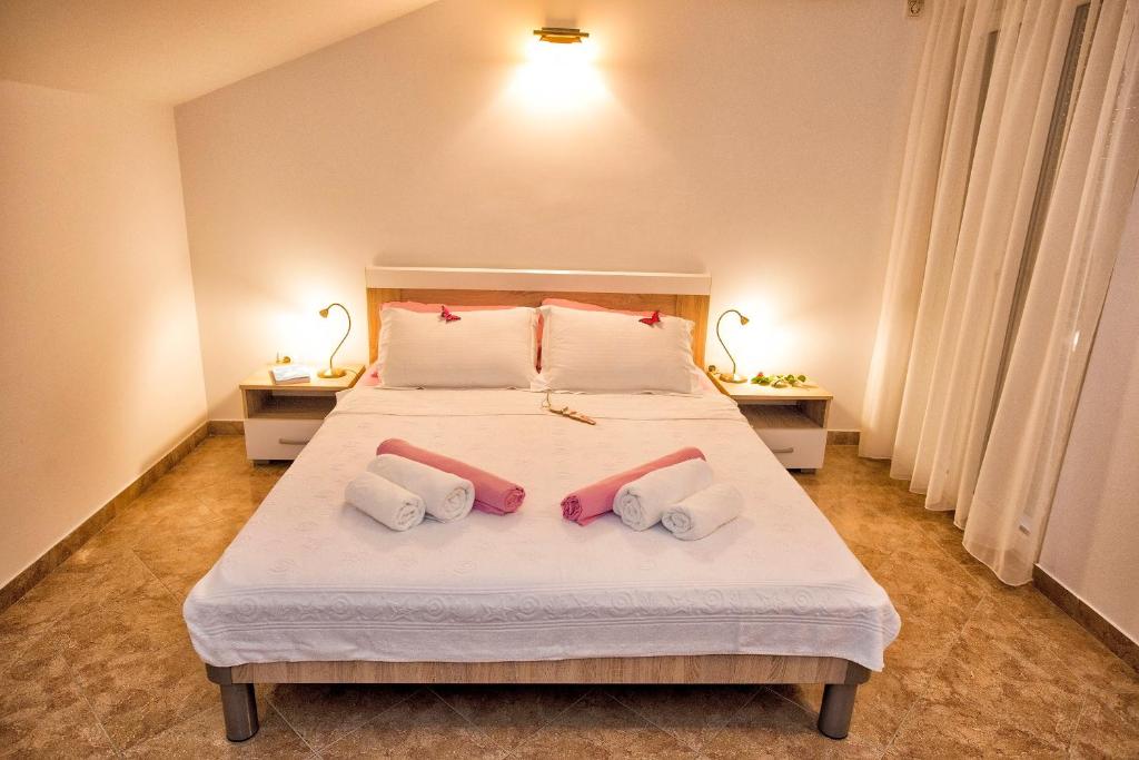 una camera da letto con un letto con tre cuscini sopra di Apartment Sun Village Goran a Herceg-Novi