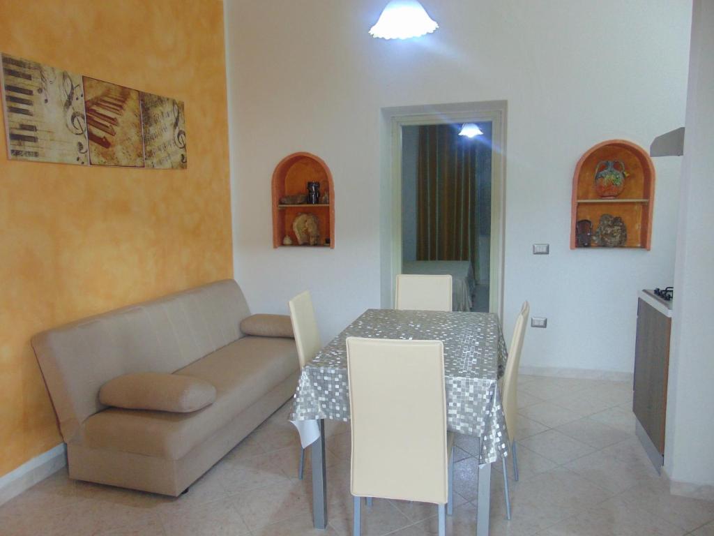 een woonkamer met een tafel en een bank bij Appartamenti Budoni in Budoni
