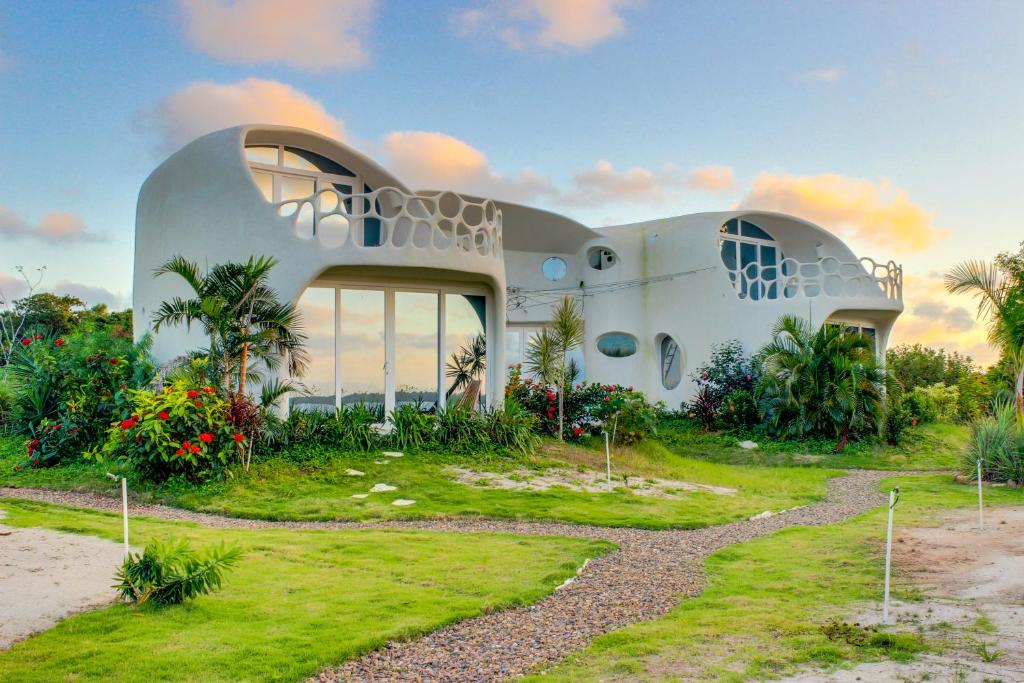 uma casa com um jardim em frente em Swan Villas em Maya Beach