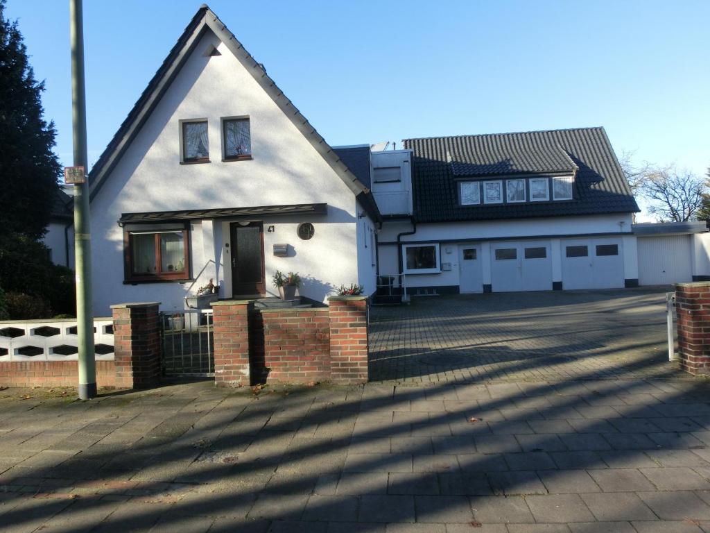 a white house with a driveway in front of it at Sommer Gästehaus in Bremerhaven