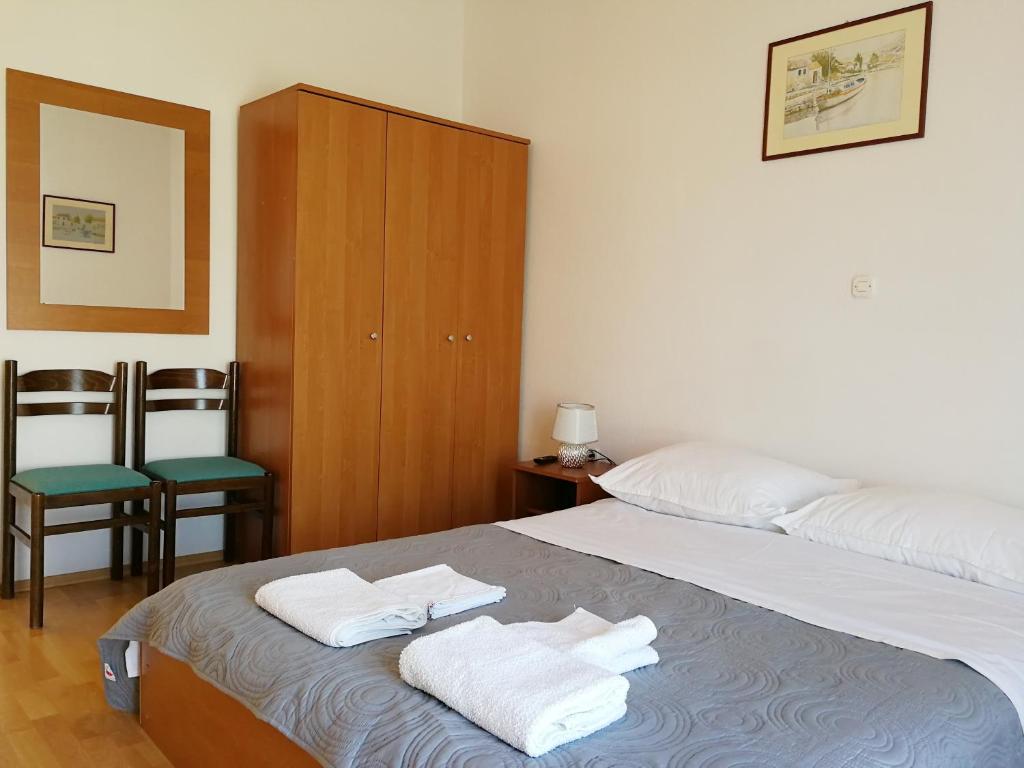 a bedroom with a bed with two towels on it at Apartmani Rija 3 in Pag