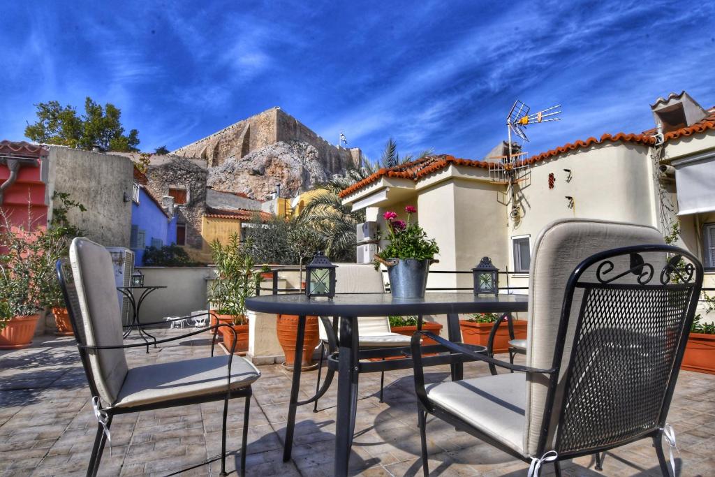 een patio met een tafel en stoelen met een berg op de achtergrond bij Athens Authentic Elegance at Acropolis in Athene