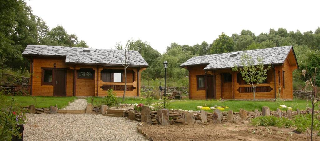 eine Blockhütte mit einem Garten davor in der Unterkunft La Albarina in Galende