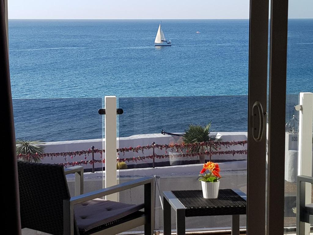 a view of the ocean from a balcony with a sailboat at Apartamentos Capellania in Puerto del Carmen