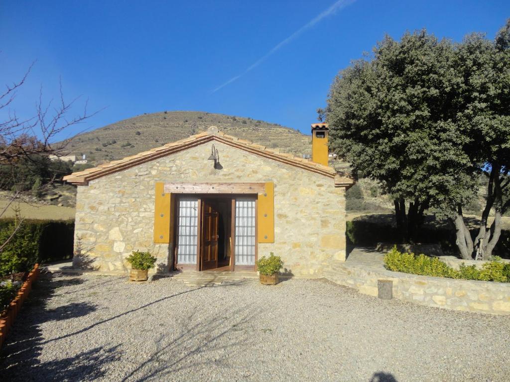 a small stone building with a large door at La Casa Del Llano in Olocau del Rey