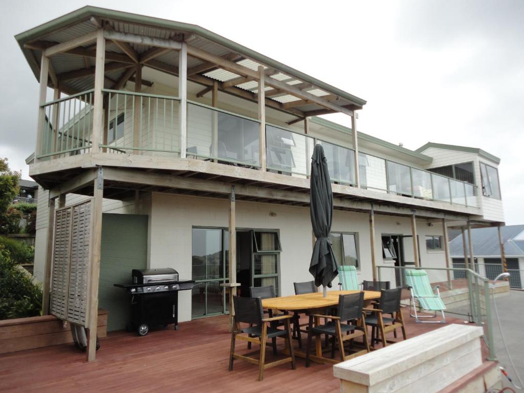 a house with a deck with a table and chairs at Ocean View B&B in Whitianga