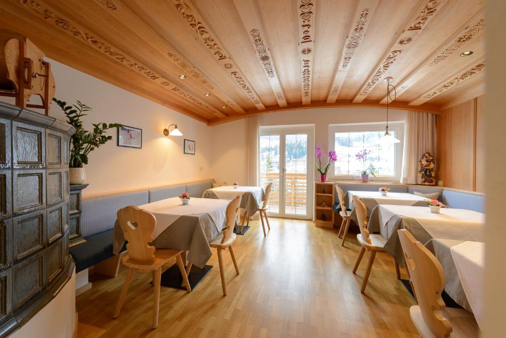 a restaurant with tables and chairs in a room at Luxury B&B August in Ortisei