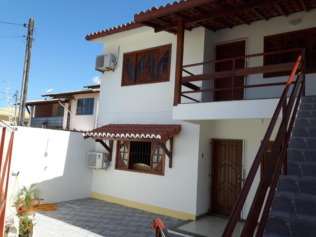 une maison blanche avec un escalier et un balcon. dans l'établissement Apto em Porto Seguro - Centro, à Porto Seguro