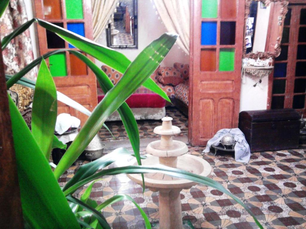 sala de estar con mesa y planta en Dar Lalla Bouchra, en Fez