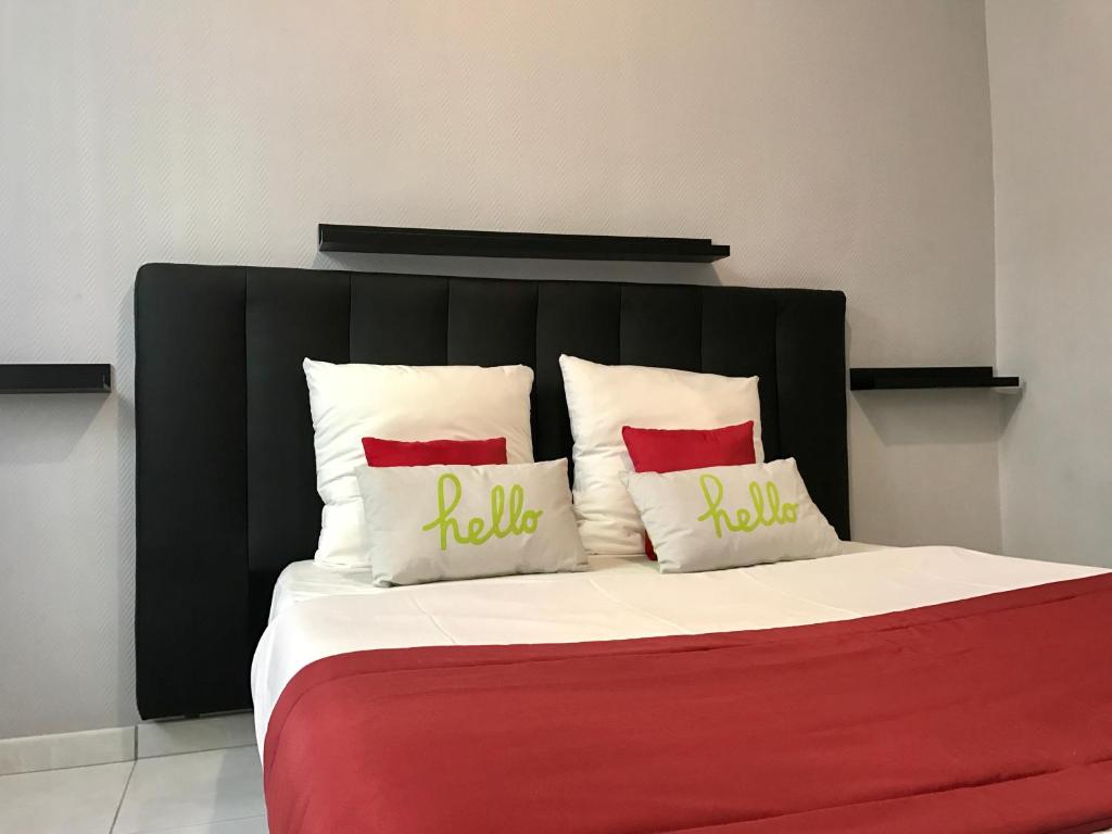 uma cama com uma cabeceira preta e duas almofadas vermelhas em Appartement Le Saint-Charles - Canebière em Marselha
