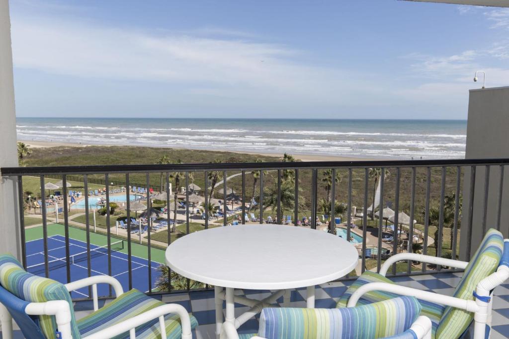 a balcony with a table and chairs and the beach at Saida in South Padre Island