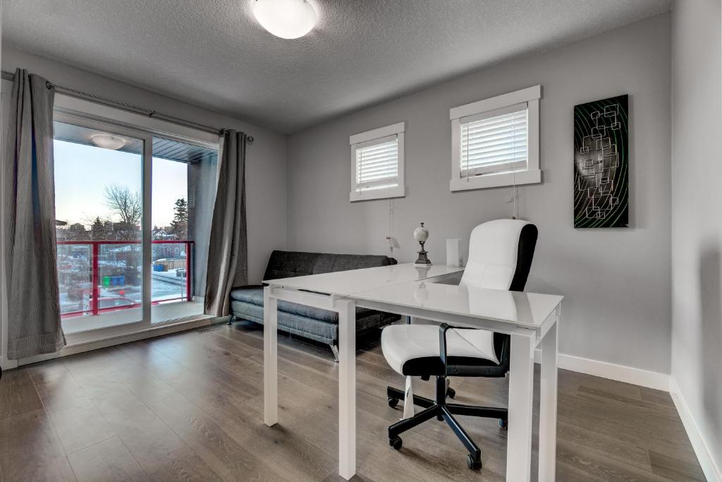 a white desk and chair in a room with a window at Three-Bedroom with Fireplace #41 Sunalta Downtown in Calgary