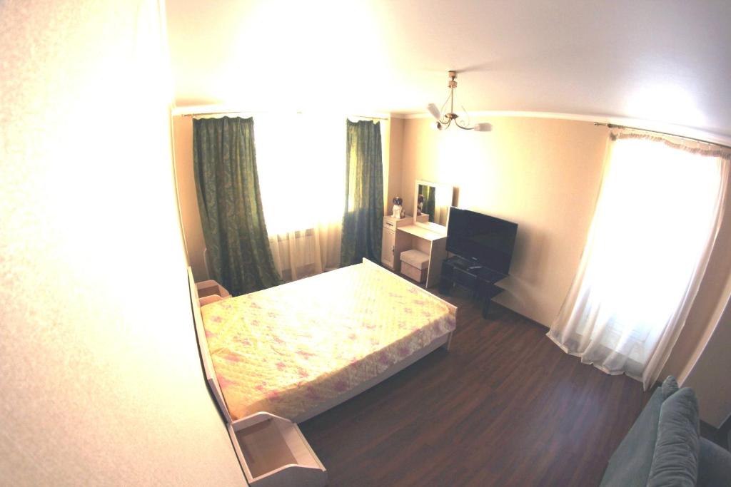 a bedroom with a bed and a desk and a mirror at Studio in the center VLKSM 13 in Tyumen