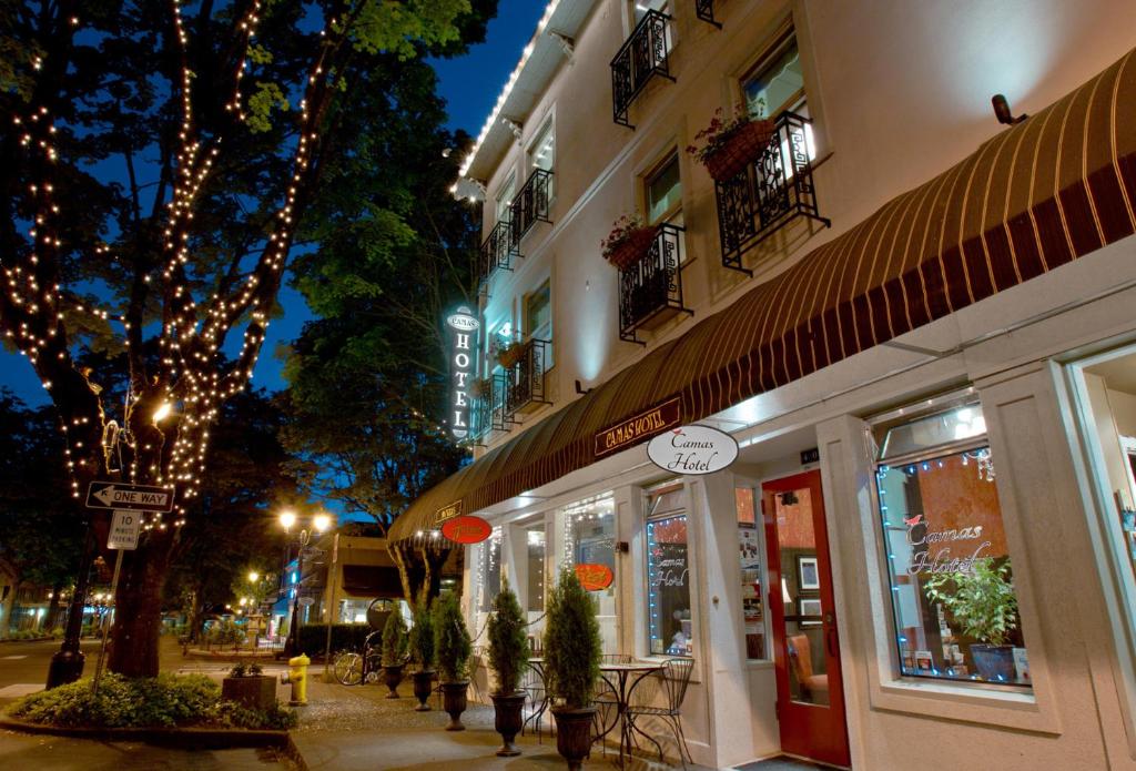 a city street at night with a store at Camas Boutique Hotel in Camas