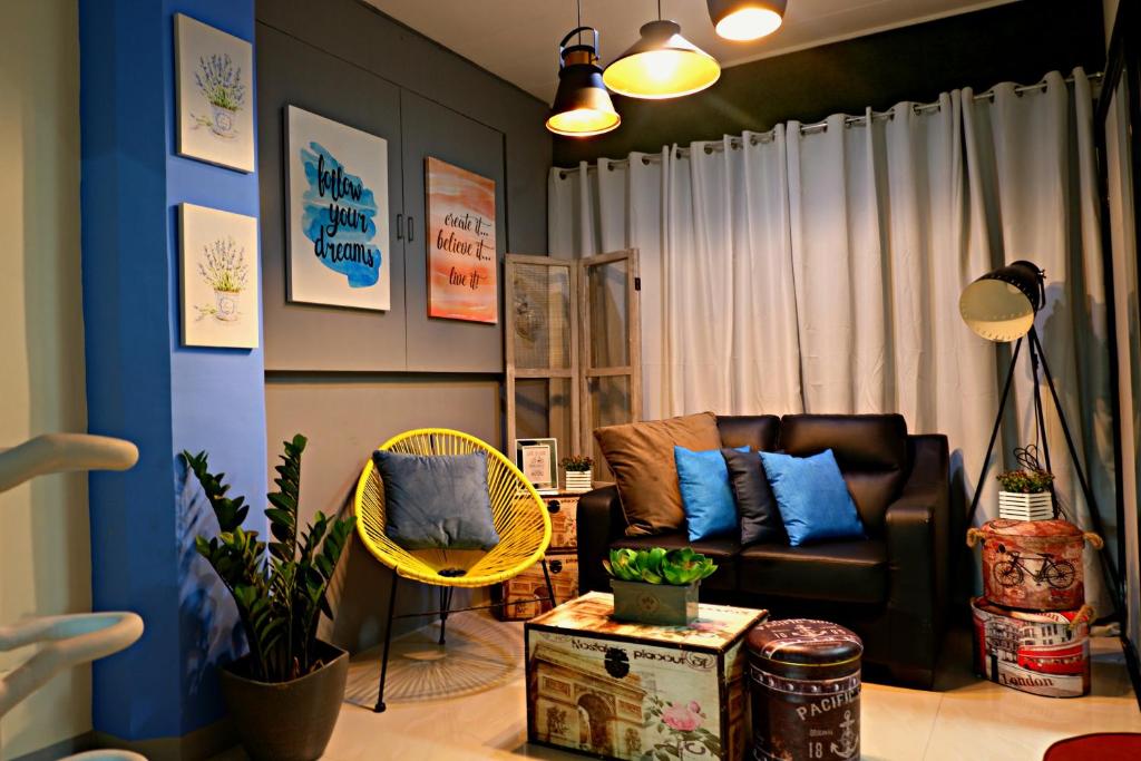 sala de estar con sofá y silla en Transit Point Hostel Mactan Cebu, en Mactan