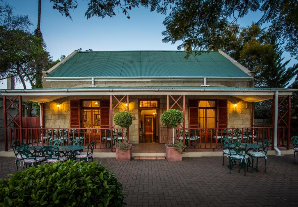 un restaurante con mesas y sillas frente a un edificio en 88 Baron van Reede Guesthouse, en Oudtshoorn