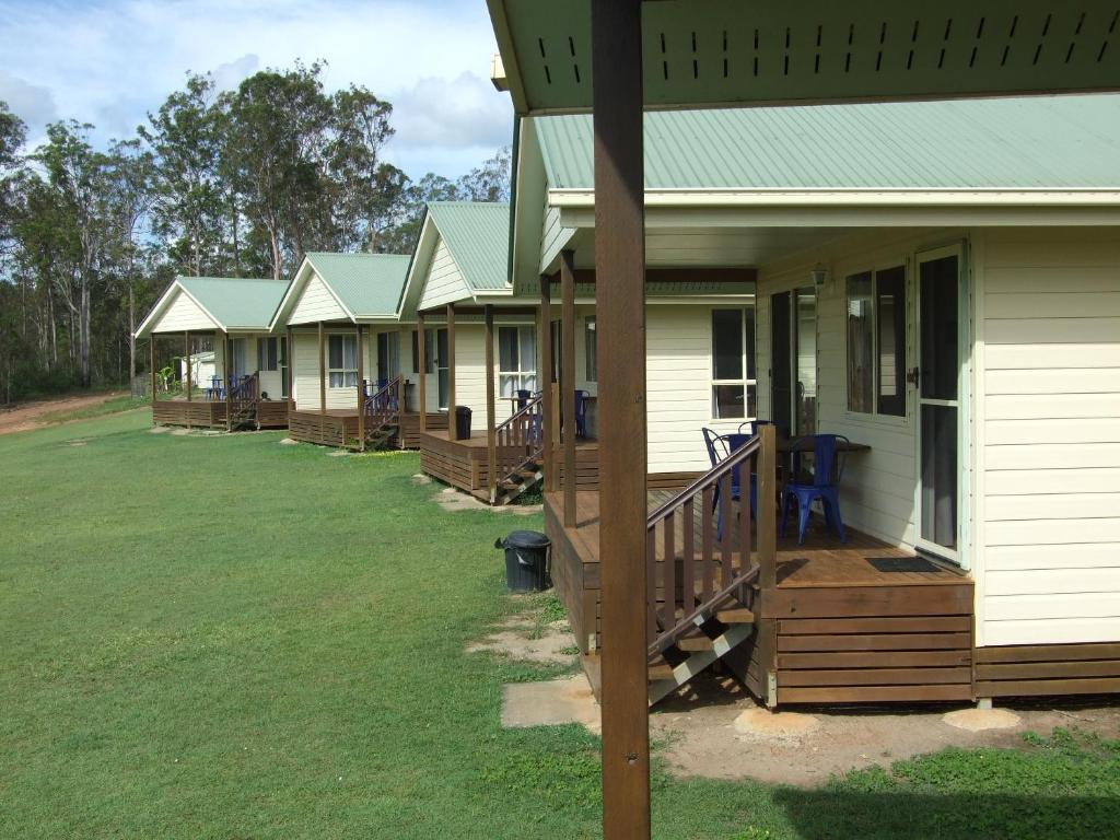 a row of houses with wooden decks on a lawn at Lake Barra Cottages in Downsfield